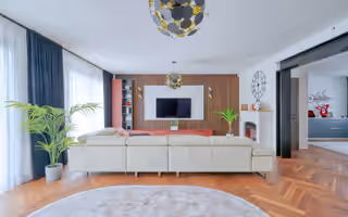 Séjour d’une maison rénovée à Vaires-sur-Marne, canapé face au mur en tasseaux de bois, parquet en point de Hongrie